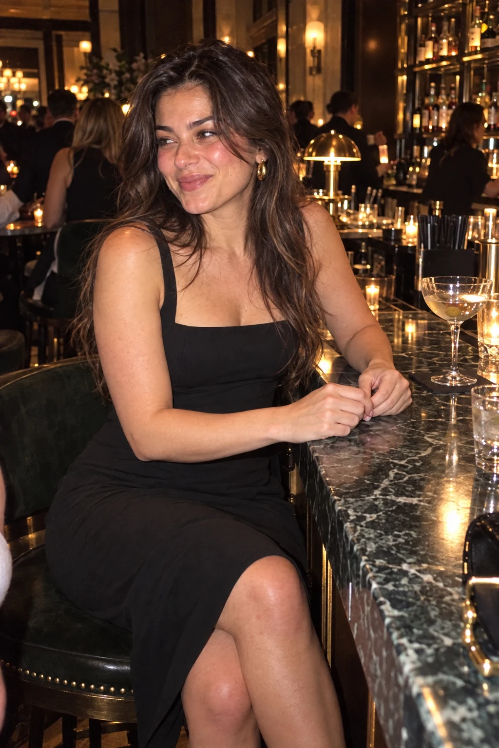Candid phone-flash photo of Nadia laughing at a bar in a black cocktail dress